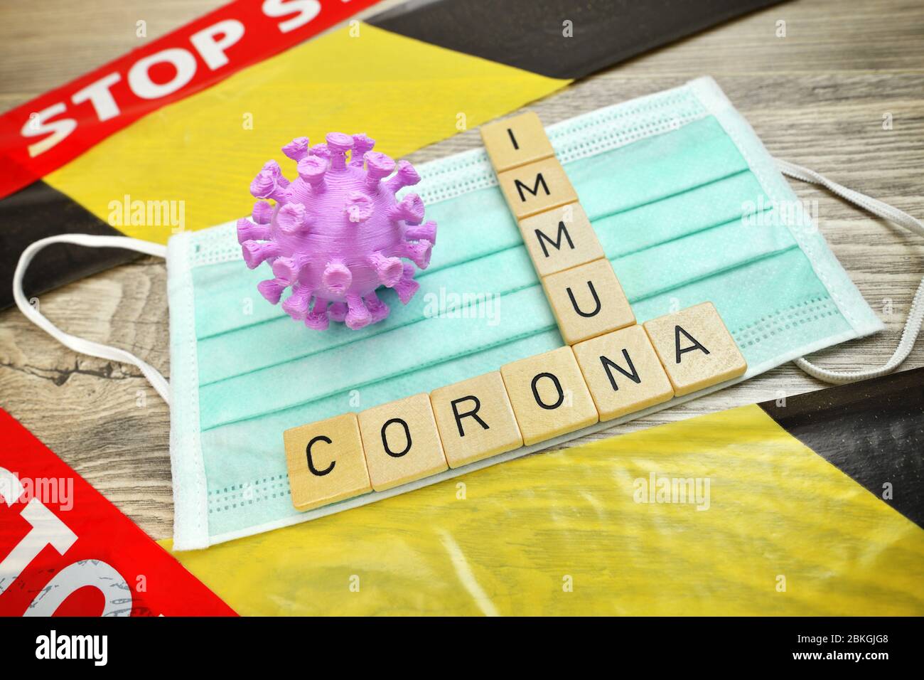 Game letters forming the words Corona and immune to a protective mask, Symbolfoto coronavirus Immunity  /  Spielbuchstaben bilden die Worte Corona und Stock Photo