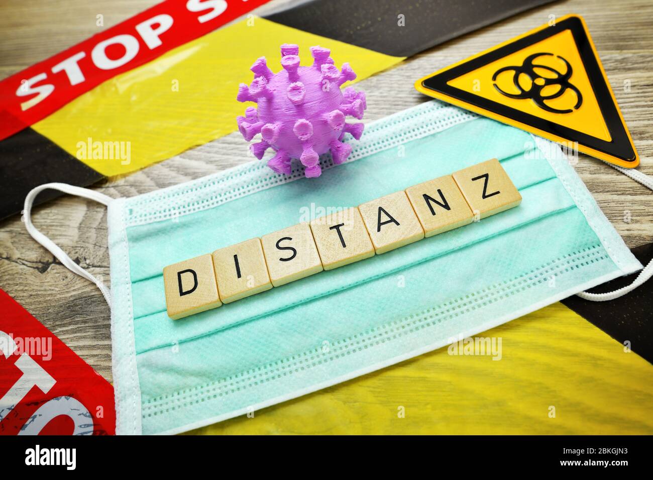 Game letters forming the word distance on a protective mask, coronavirus pandemic and corona measures  /  Spielbuchstaben bilden das Wort Distanz auf Stock Photo