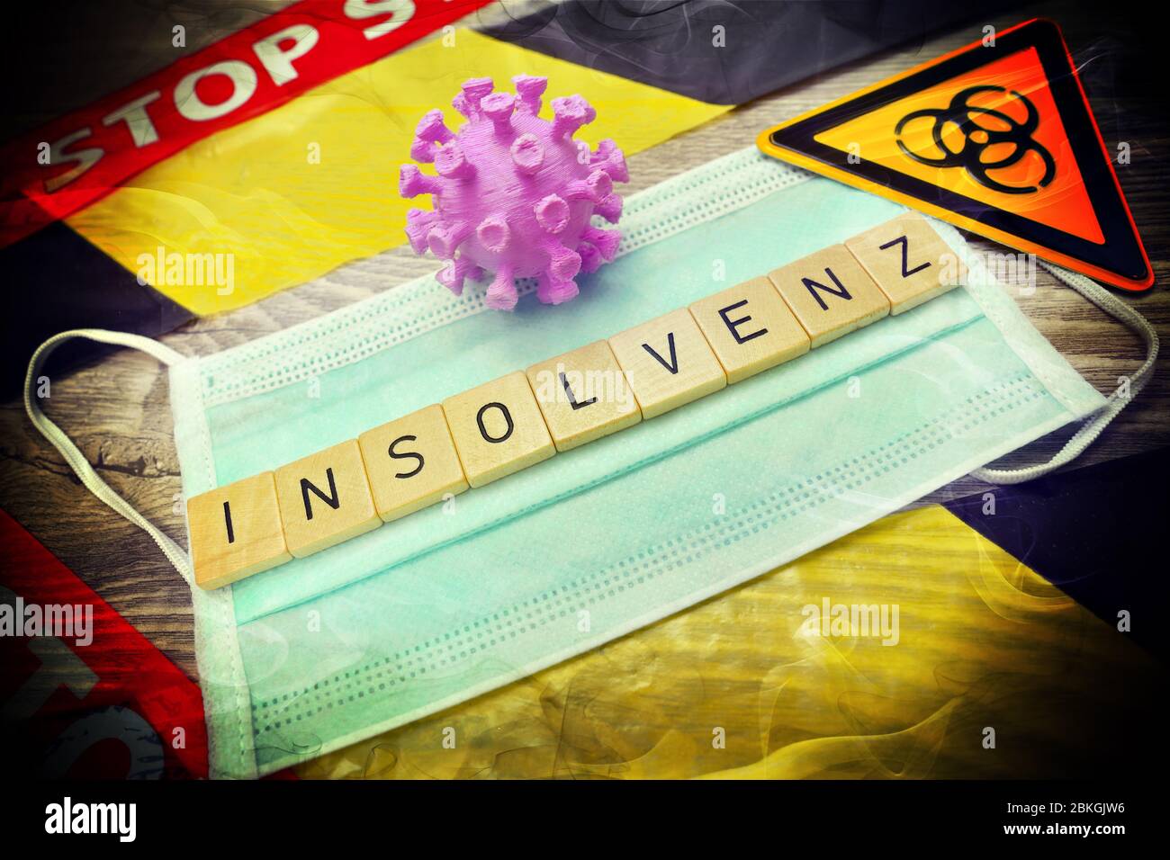 Game letters forming the word bankruptcy on a protective mask coronavirus pandemic and economic crisis  /  Spielbuchstaben bilden das Wort Insolvenz a Stock Photo