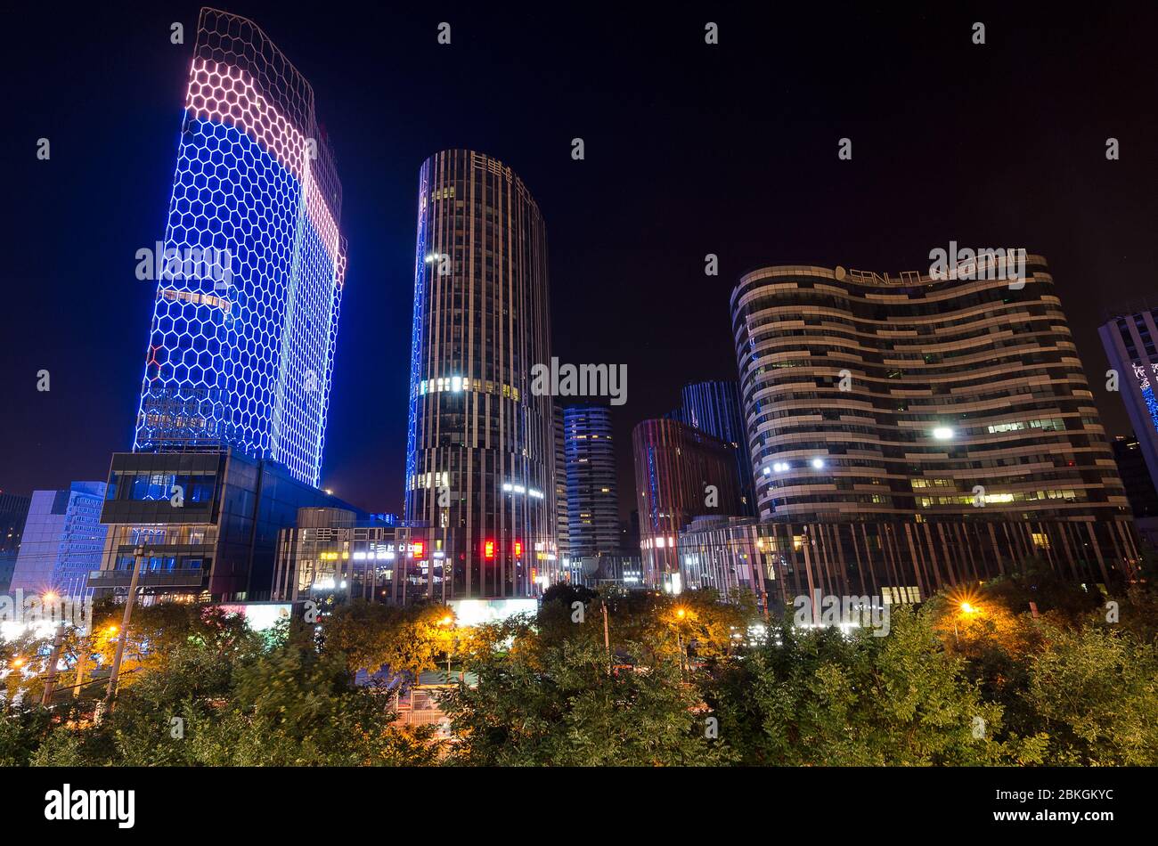 Beijing / China - July 2nd 2016: Night view of the futuristic architecture of Sanlitun Soho buildings in downtown Beijing. Sanlitun Soho is luxurious Stock Photo