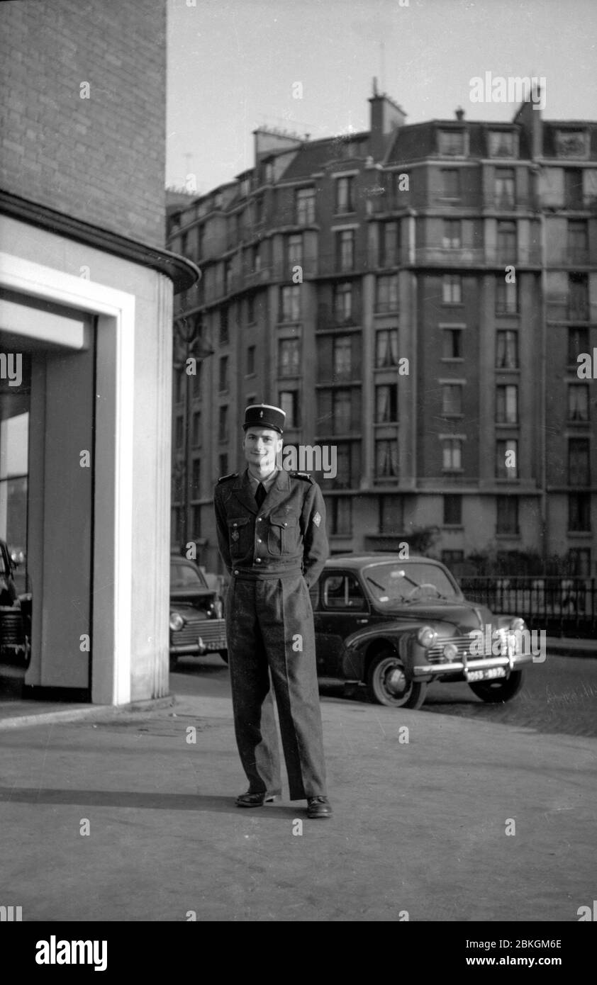 A French soldier poses on a Paris street wearing his uniform and traditional kepi hat, taken in the 1960s Stock Photo