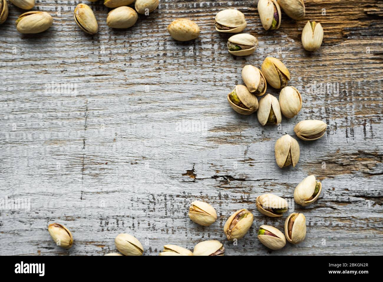 Pistachios scattered on the wooden vintage table. Pistachio is a