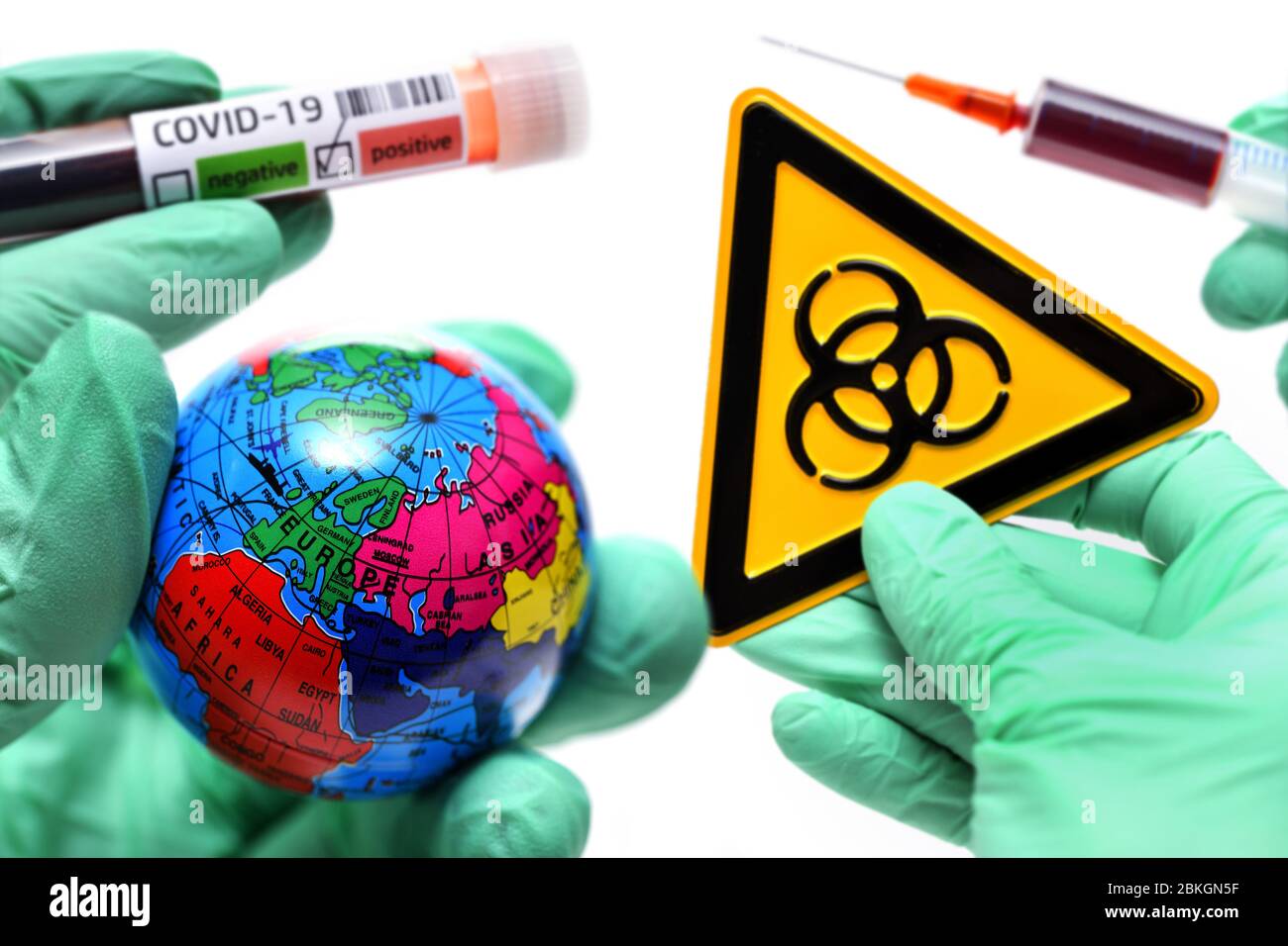 PHOTOMONTAGE, hands in latex gloves holding globe, blood collection tubes, Biogefährdungsschild