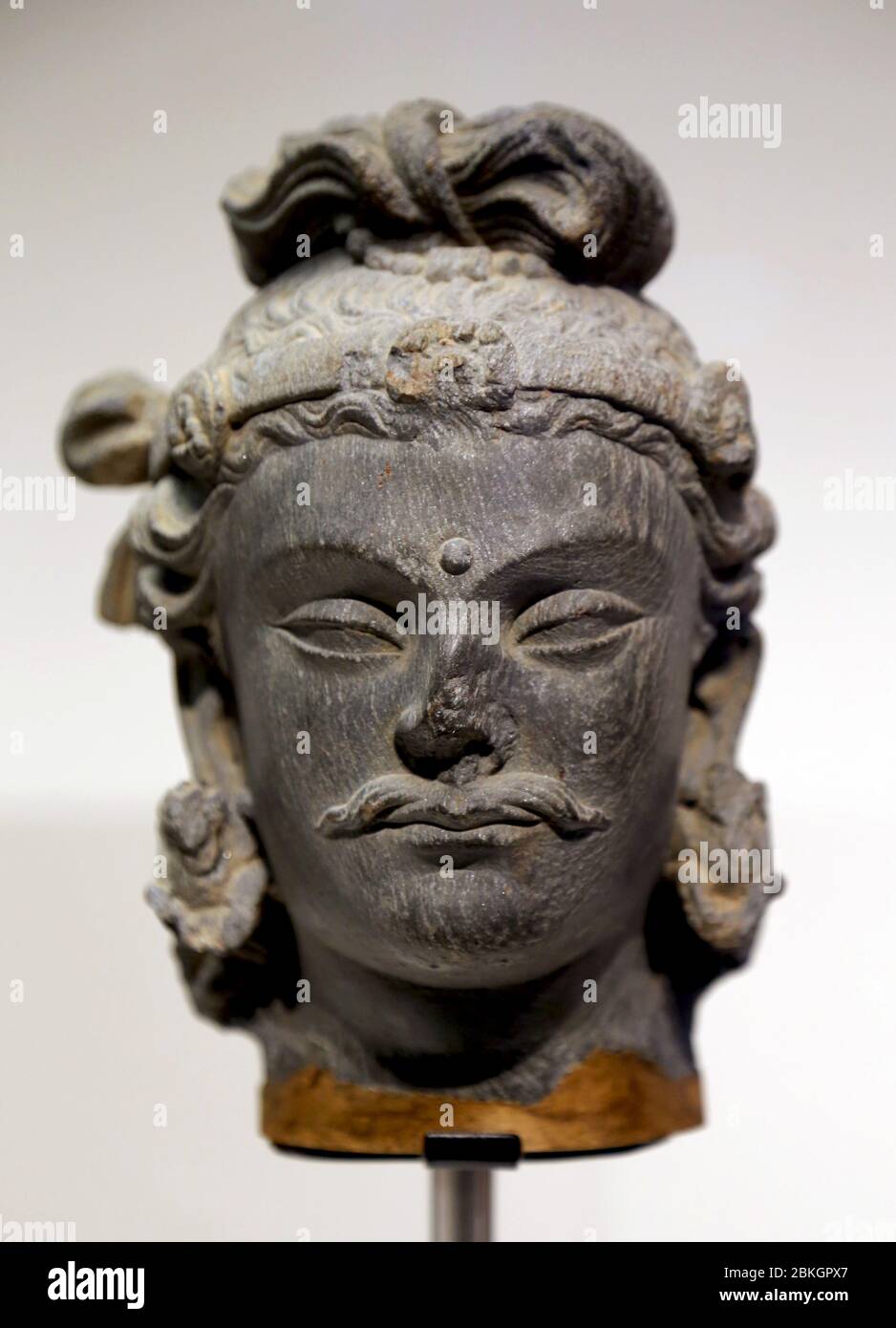 Head of Bodhisattva Maitreya, schist stone (1st-3rd cent. AD) Gandhara Period, Pakistan or Afghanistan. Museum World Cultures, Barcelona. Stock Photo
