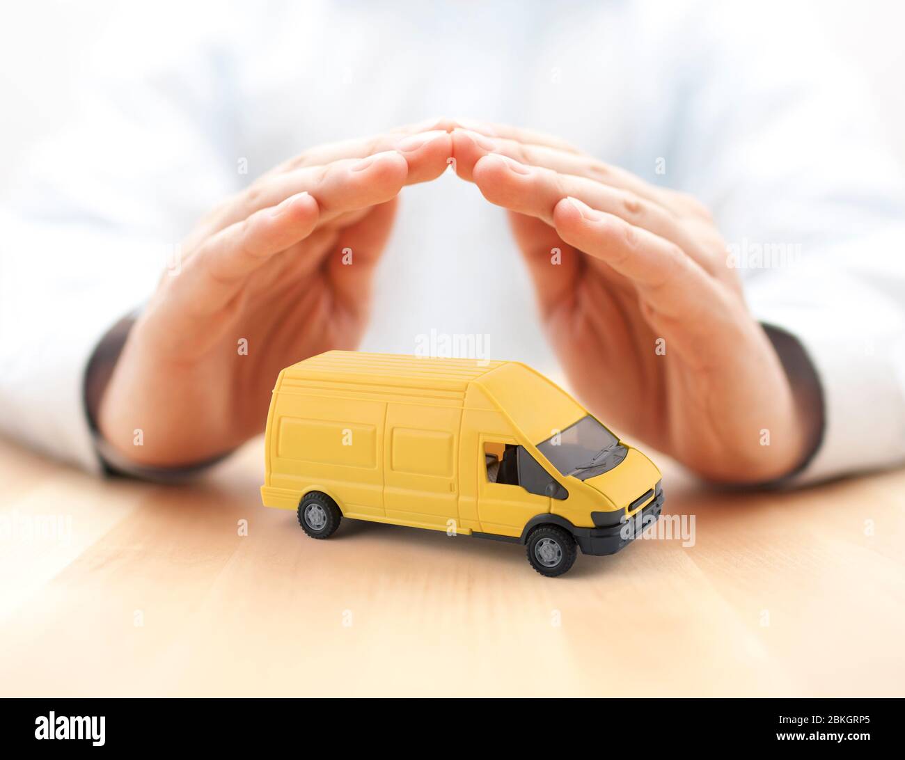 Transport yellow van car protected by hands Stock Photo
