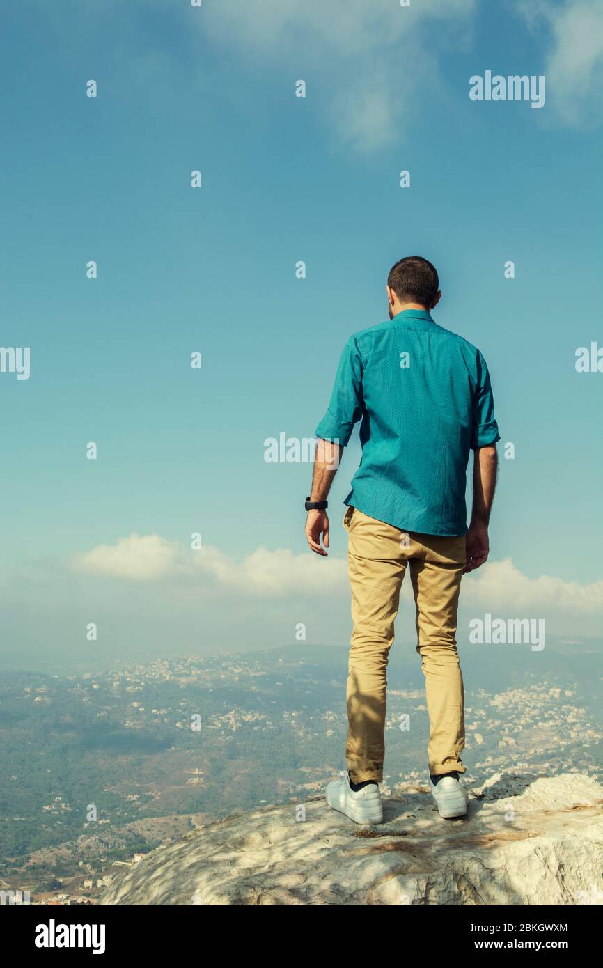 Full length rear view of man standing on top of mountain Stock Photo