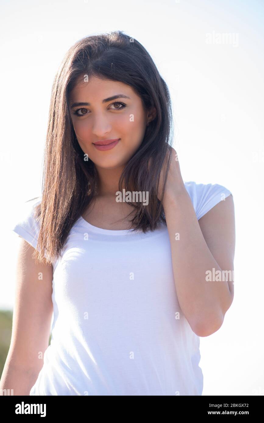 Beautiful young woman looking at camera outdoors Stock Photo