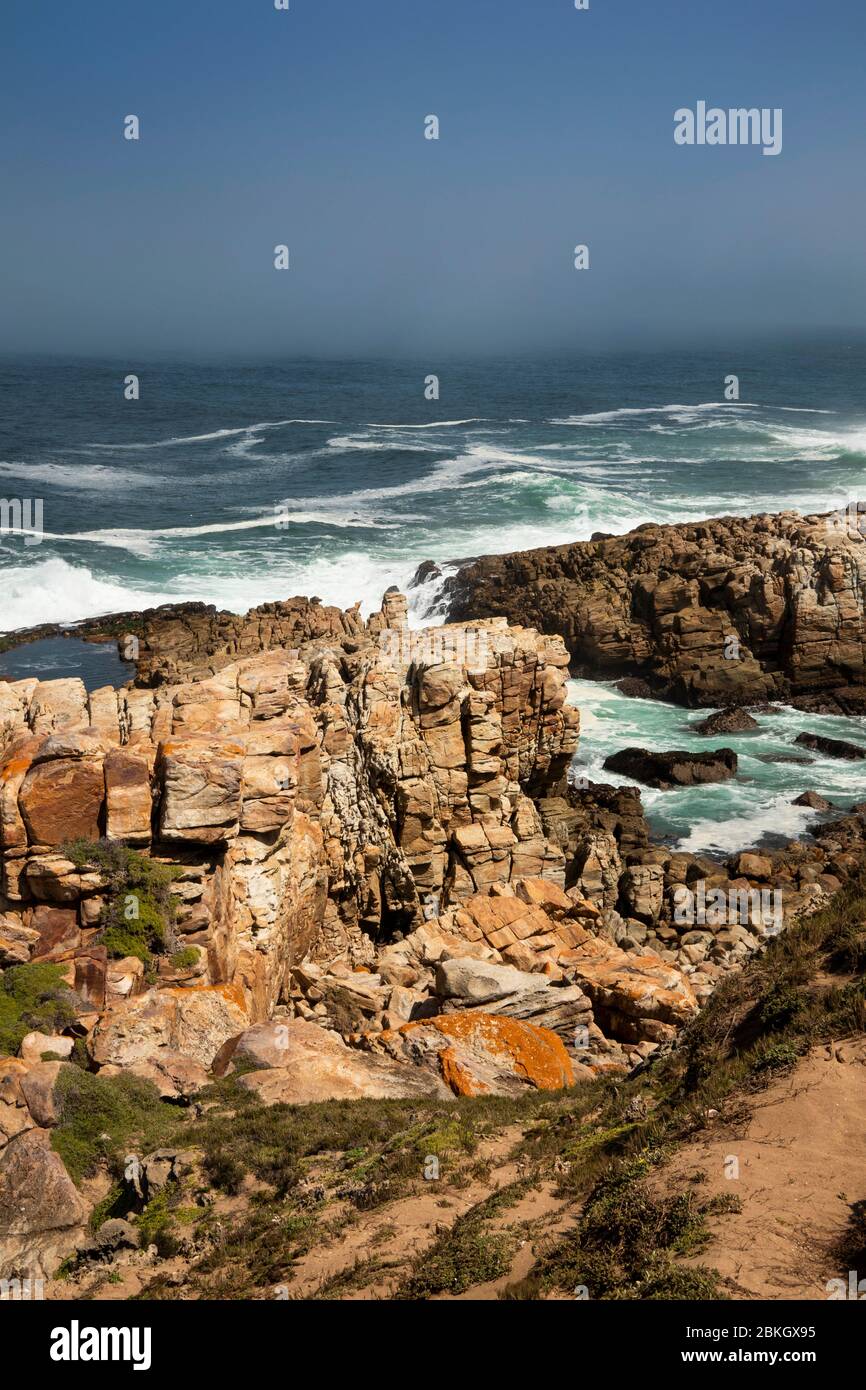 South Africa, Western Cape, Plettenberg Bay, Robberg Nature Reserve, rocky coastline with waves crashing in behind Stock Photo