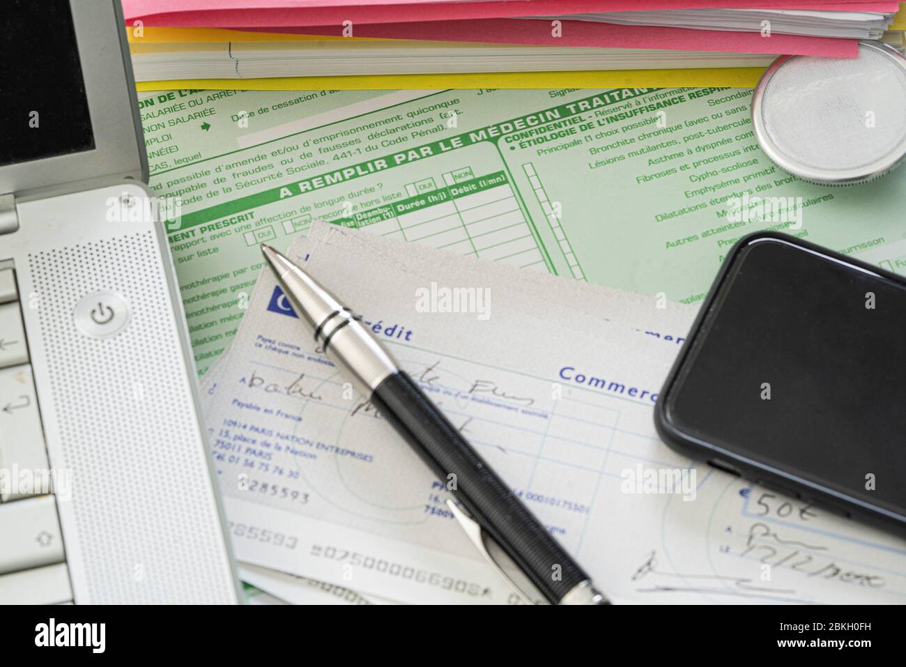 Pen, laptop, smartphone and stethoscope on medical documents Stock Photo