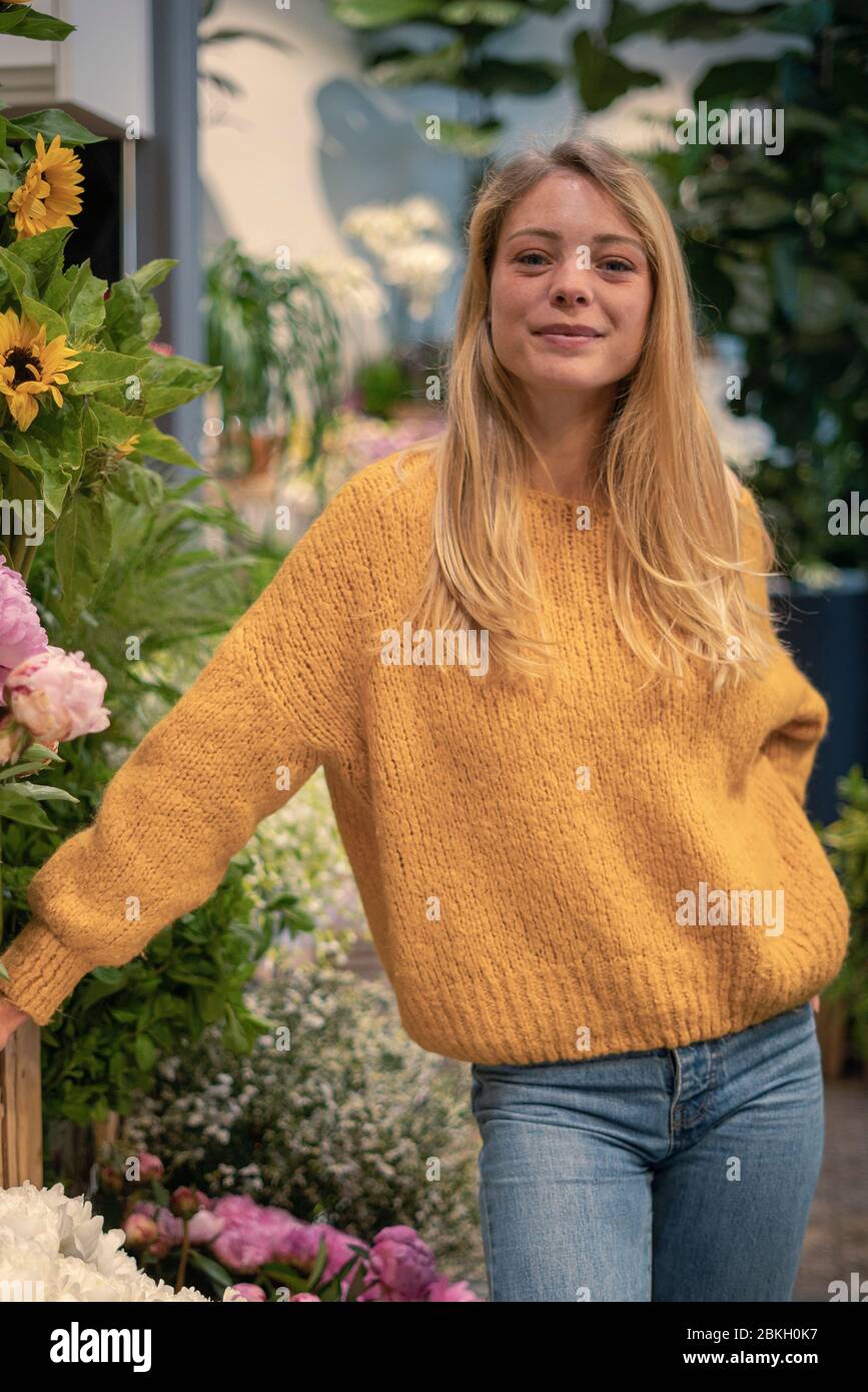 Young woman standing in flower shop Stock Photo - Alamy