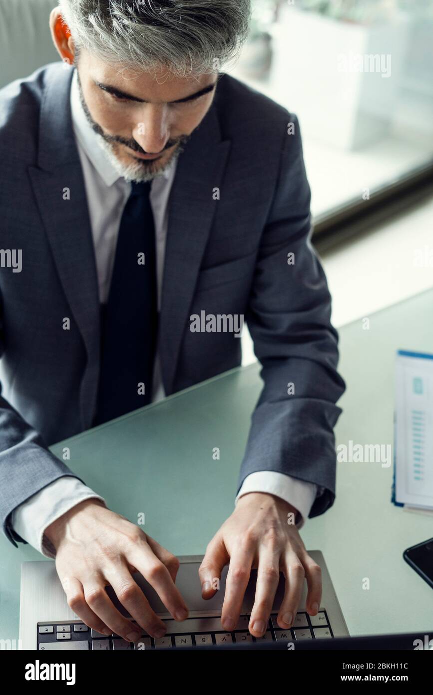 Businessman using laptop in office Stock Photo