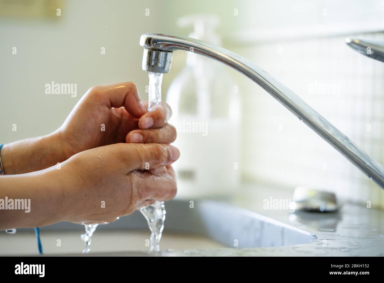 Woman washing hands with water in bathroom sink Stock Photo - Alamy