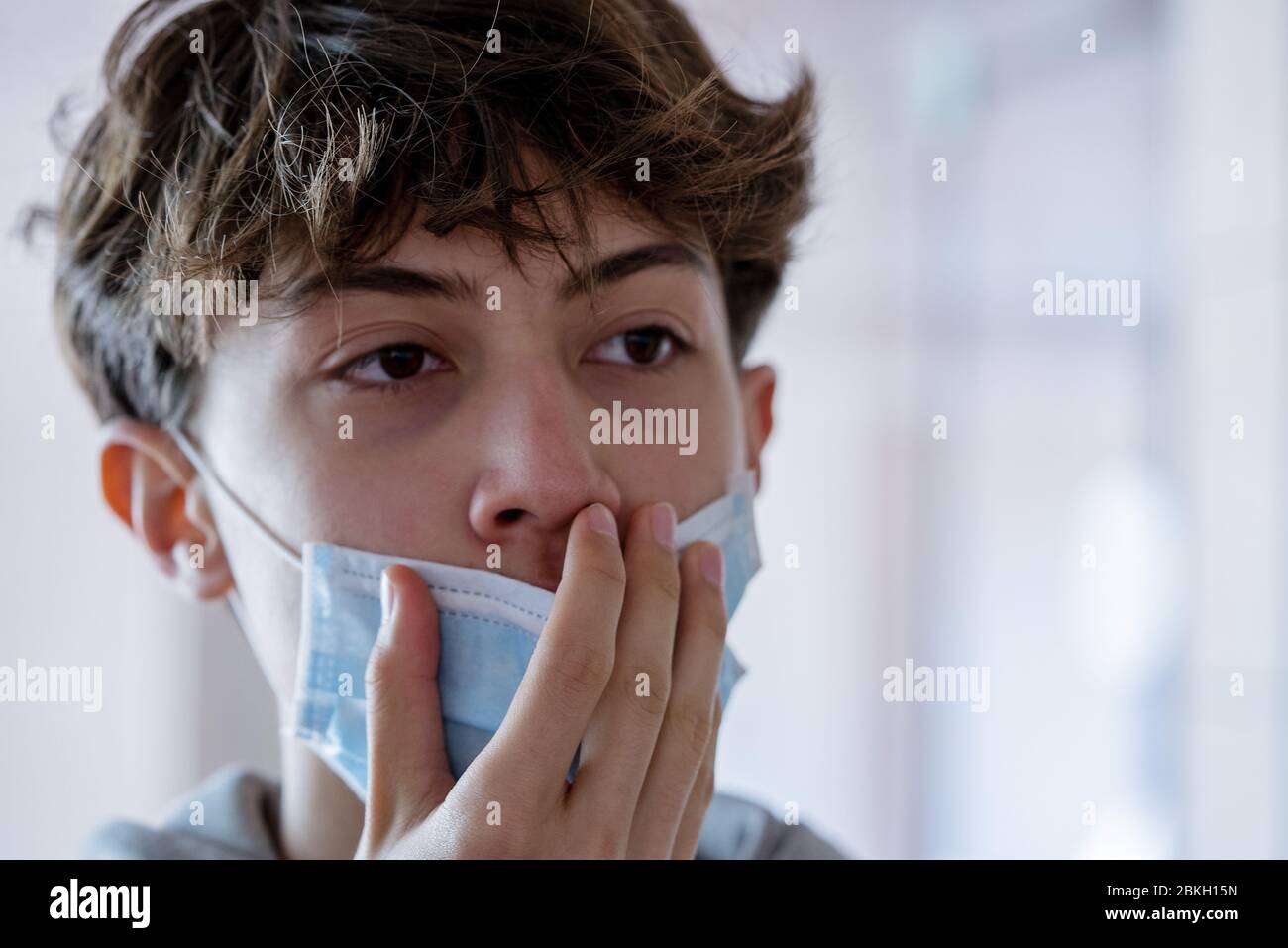Close up of teenage boy wearing blue surgical mask Stock Photo - Alamy
