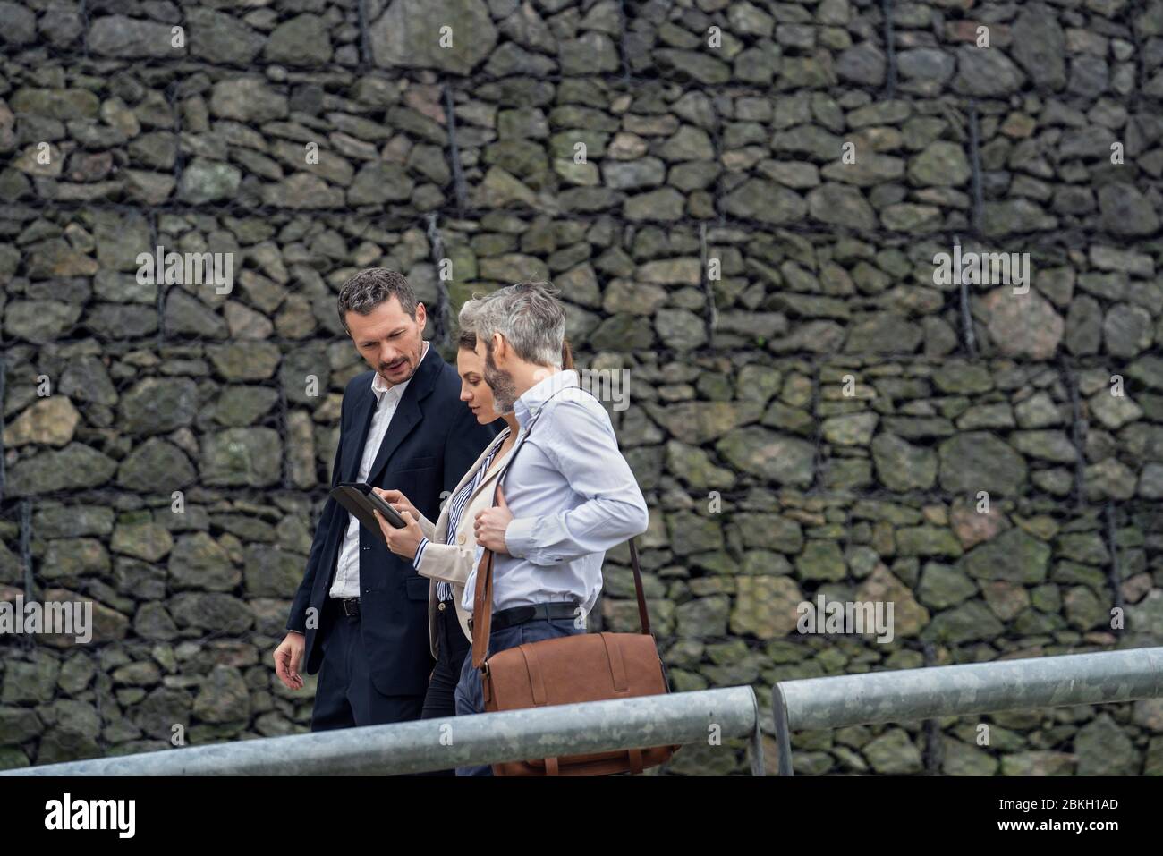 Businesspeople using digital tablet in public park Stock Photo