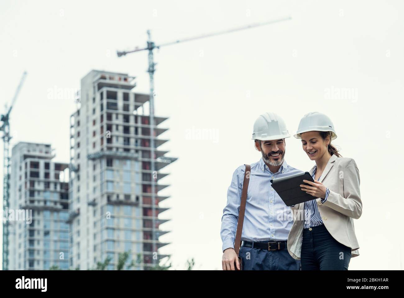 Architects using digital tablet at construction site Stock Photo