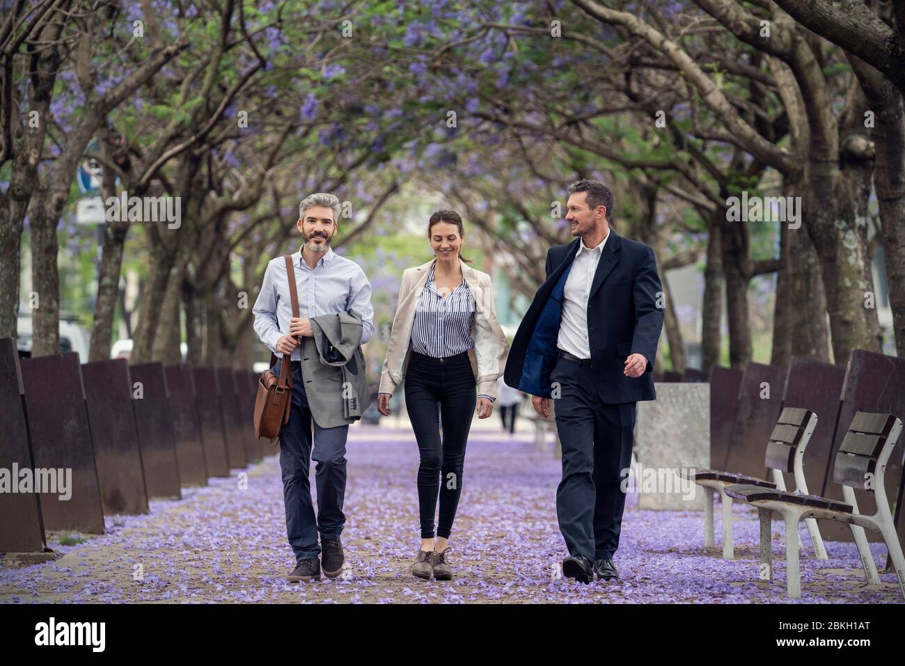 Businesspeople walking in public park Stock Photo - Alamy