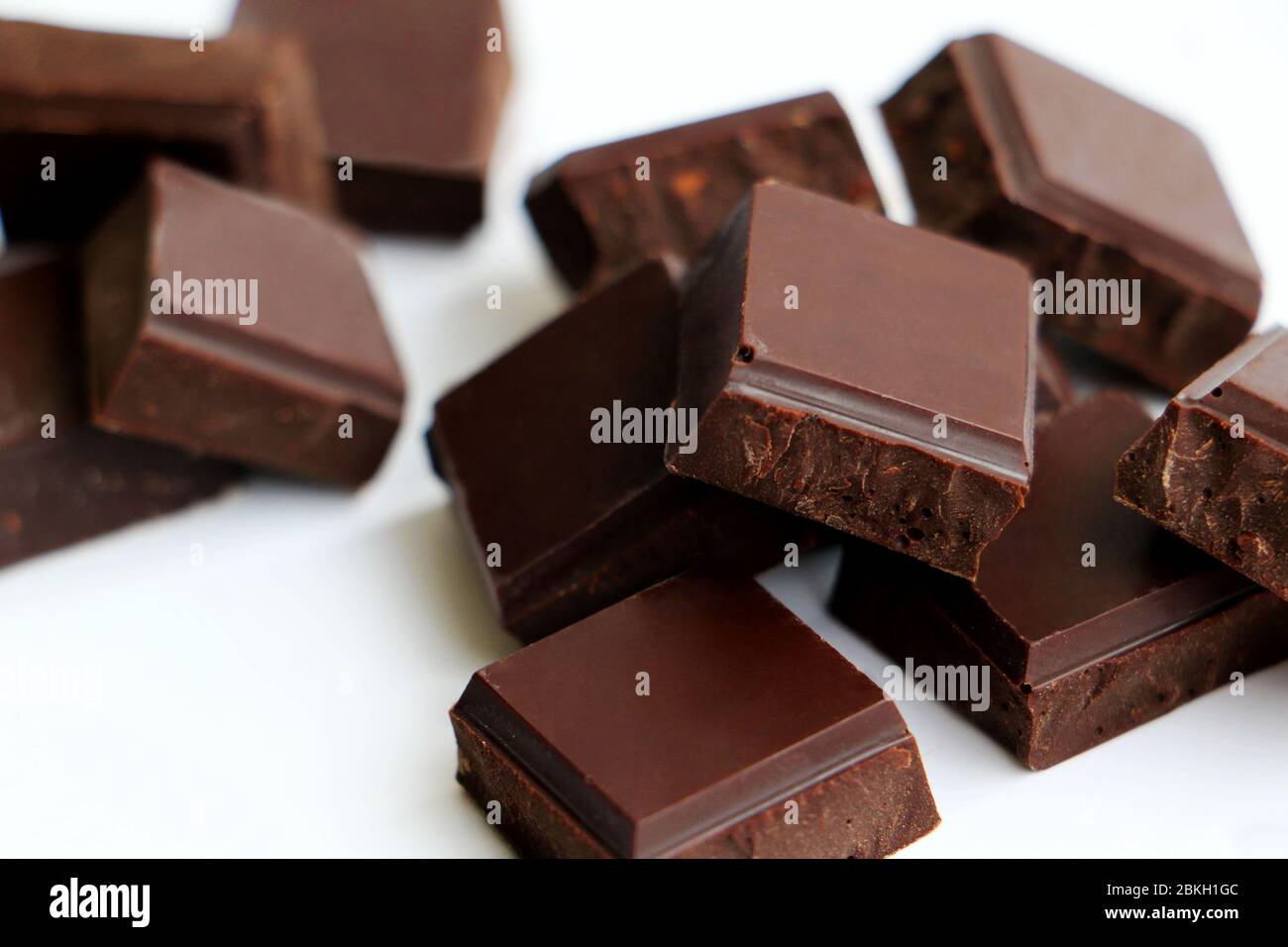 broken up chocolate pieces in a small pile isolated on a white background Stock Photo