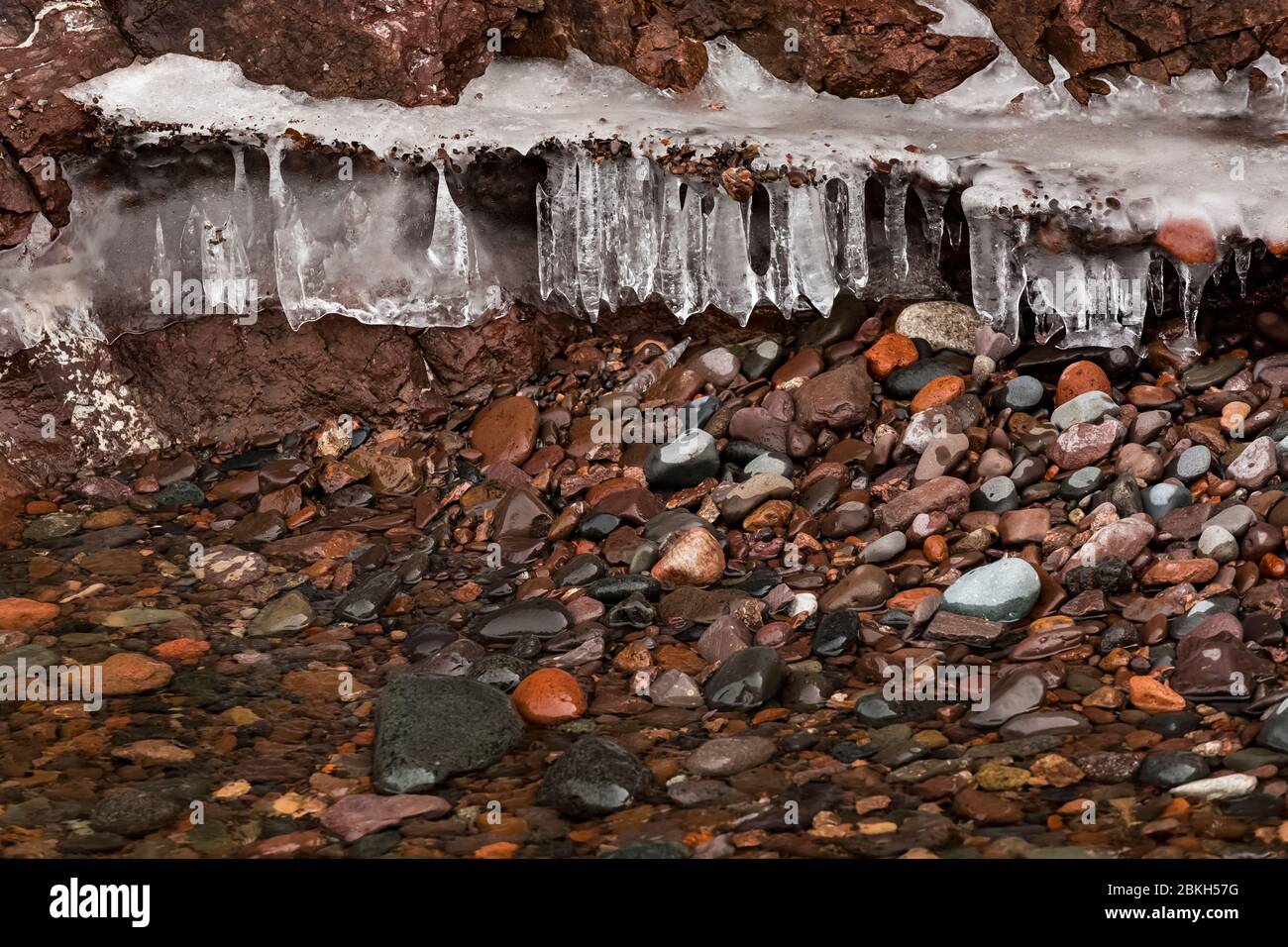 Icicles formed just above the lower beach of Lake Superior, where waves crash in and resultant water drips down by gravity, in Tettegouche State Park Stock Photo