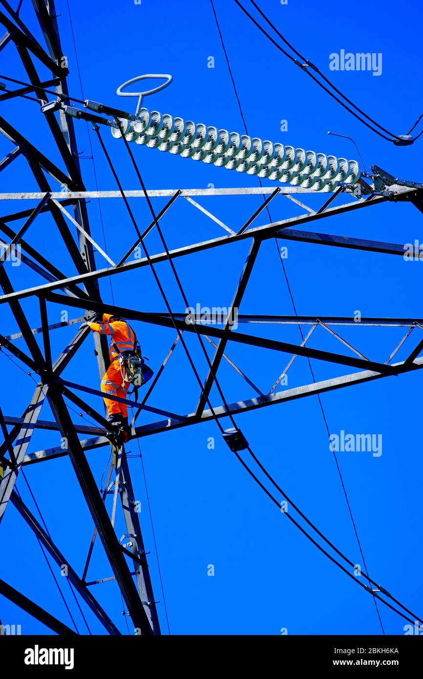Electricity power engineers working on a pylon in detail Stock Photo Alamy