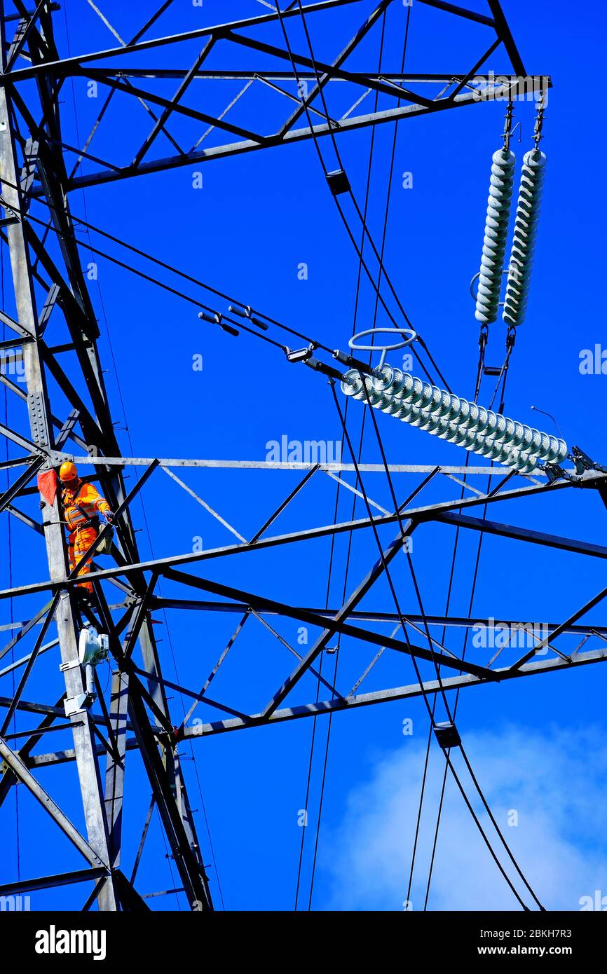 Electricity power engineers working on a pylon in detail Stock Photo