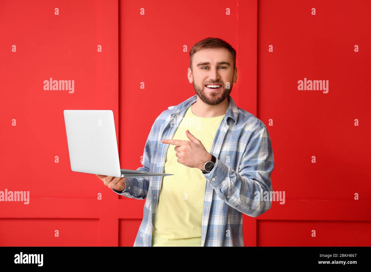 Male programmer with laptop on color background Stock Photo
