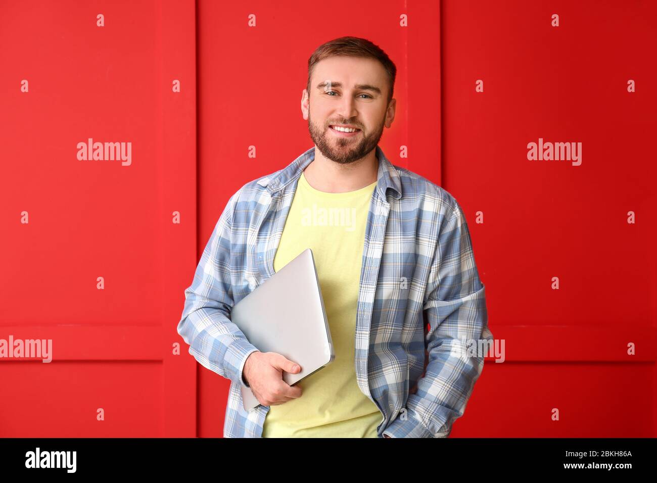 Male programmer with laptop on color background Stock Photo