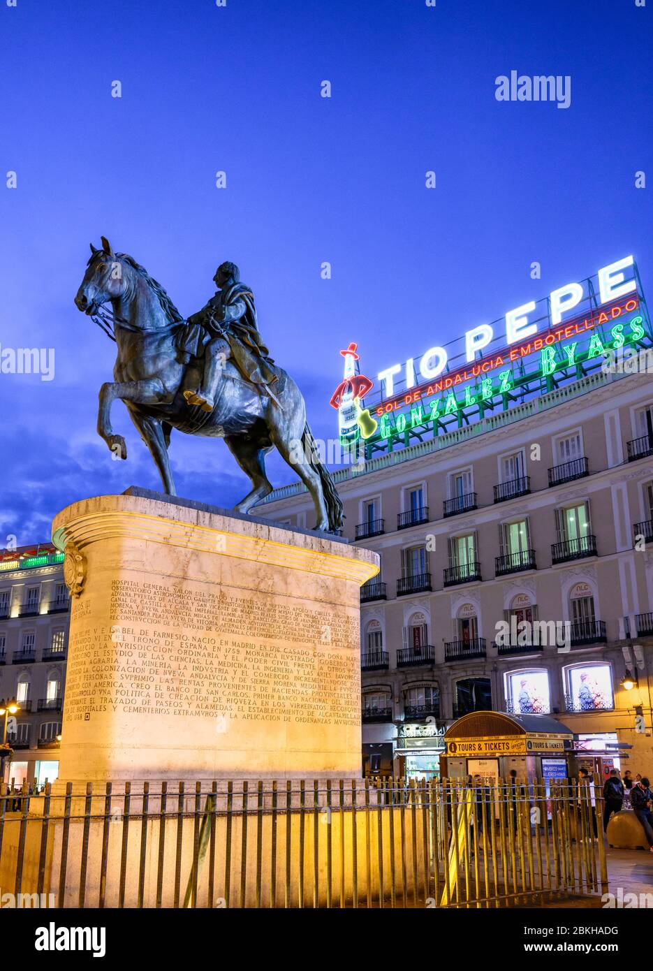 The famous Tio Pepe advertising sign looms over a statue of King Carlos III, in the Puerta del Sol,  Madrid, Spain. Stock Photo