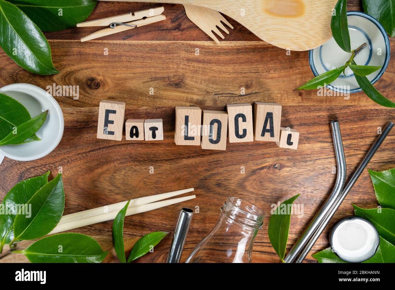 The wooden brick with words ' EAT LOCAL ' on wooden background. ECO concept with recycling symbol and leaves. Stock Photo