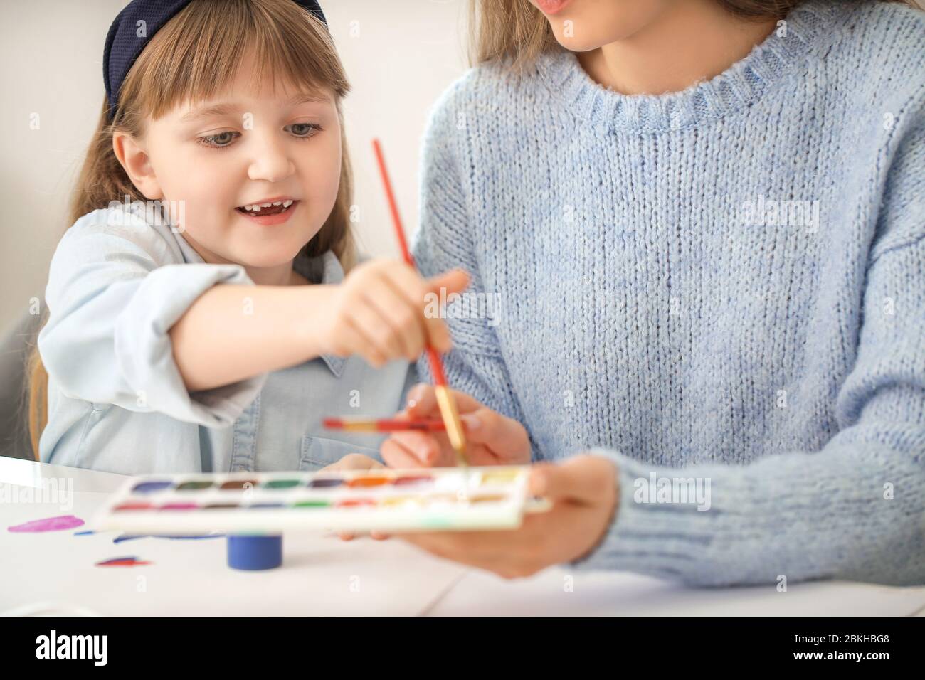 Drawing teacher giving private art lessons to little girl at home Stock Photo Alamy