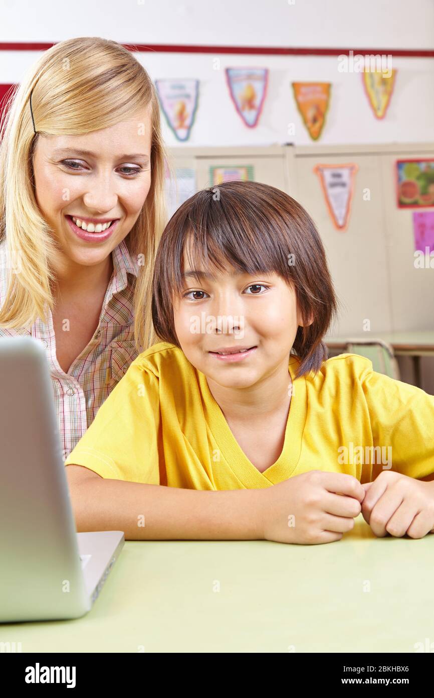 Japanese student sits at tutoring with teacher and laptop Stock Photo