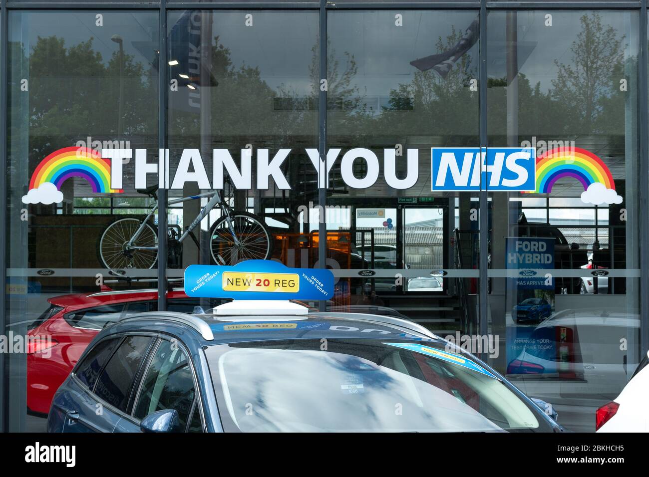 Thank you NHS rainbow sign on the showroom window of a Think Ford car dealership, UK, during the 2020 coronavirus covid-19 pandemic Stock Photo