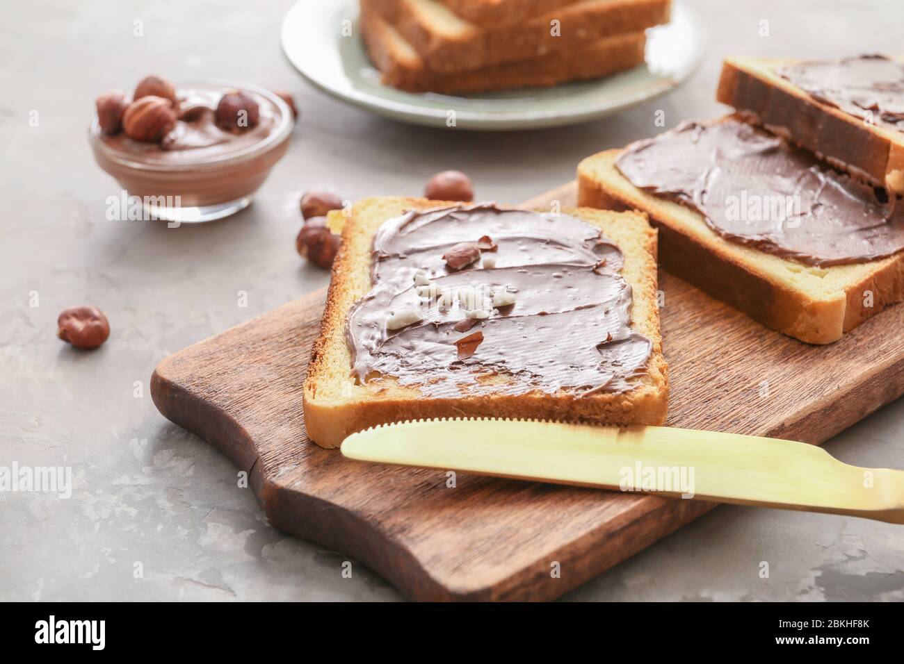 Board with fresh bread and chocolate paste on grey background Stock ...