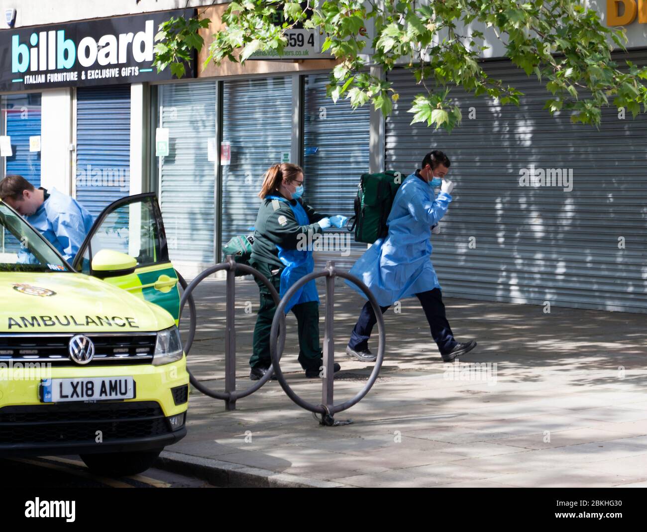 London Ambulance Crewmember's, dressed in Personal Protective Equipment, arrives in Lewisham Hight Street, to attend a medical emergency, during the COVID-19 Pandemic Stock Photo