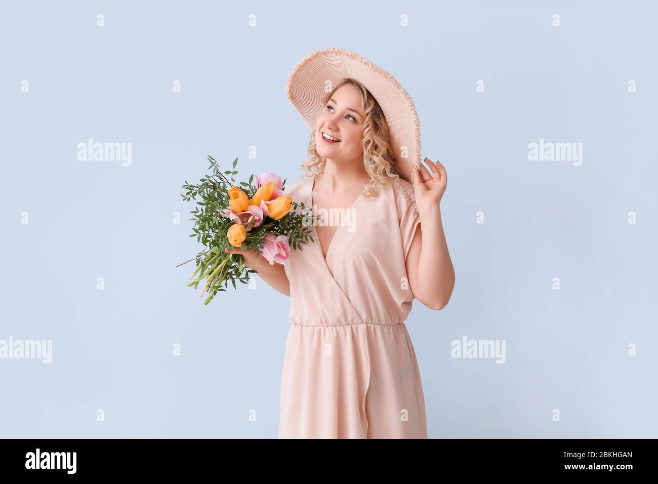 Beautiful young woman with bouquet of flowers on color background Stock ...