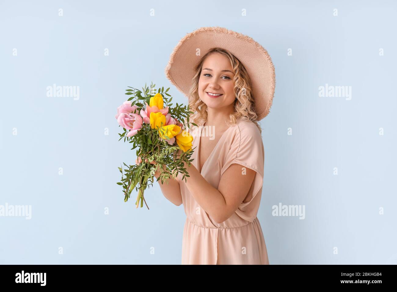 Beautiful young woman with bouquet of flowers on color background Stock ...