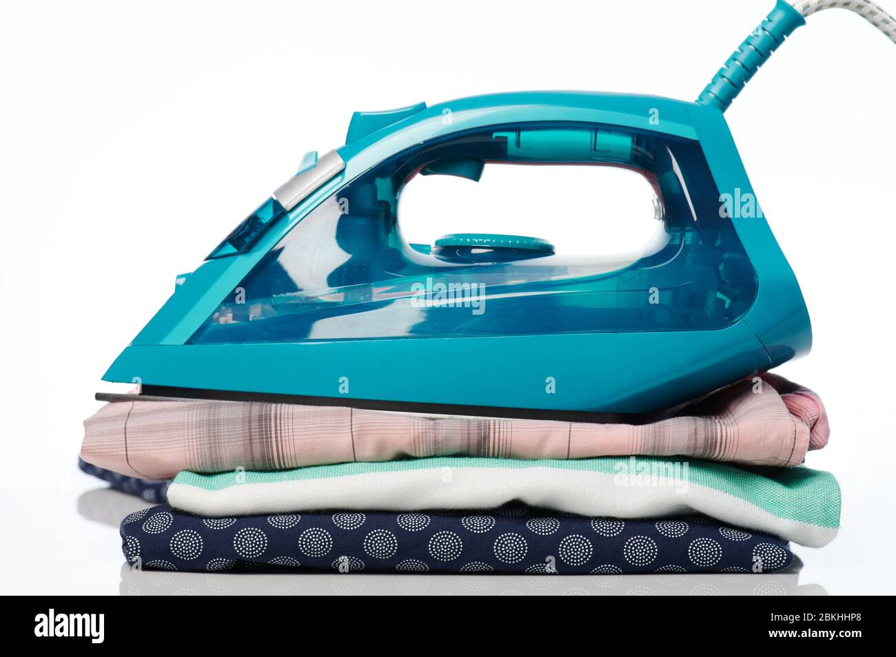 Modern iron on clean stack of clothes isolated close up veiw Stock Photo