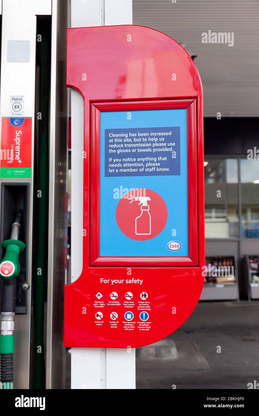 Safety Notice asking people to avoid contaminating themselves with Covid-19, whilst using Petrol Pumps, in a the Tesco Esso Express Petrol Station, on Loampit Vale, Lewisham Stock Photo