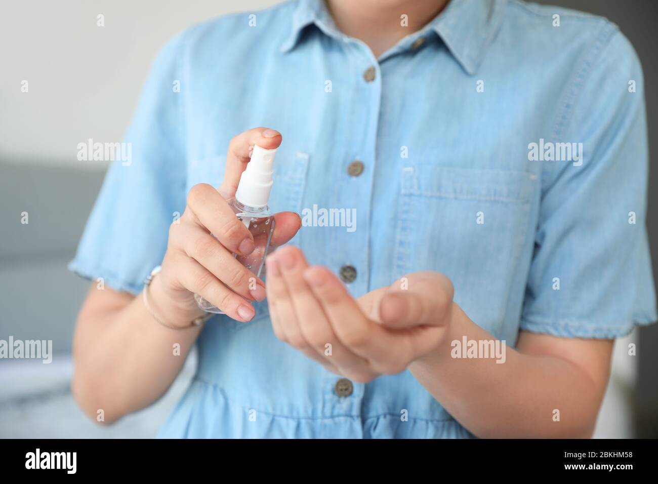 Woman applying disinfectant onto hands at home, closeup Stock Photo