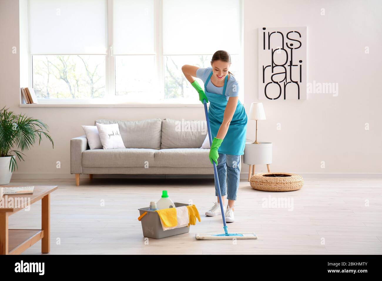 Young woman mopping floor in room Stock Photo