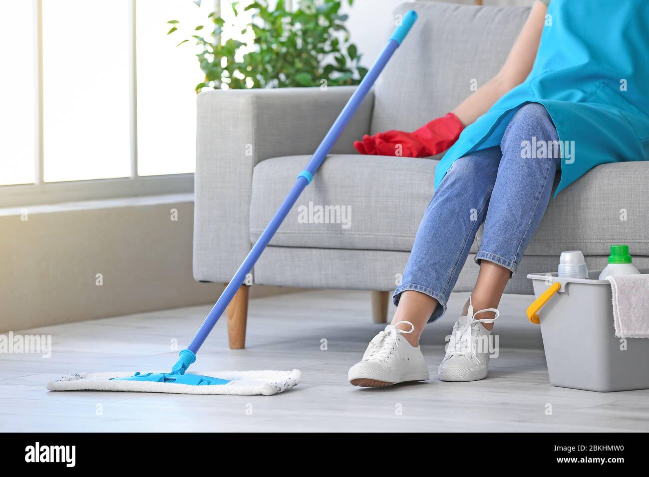 Tired young woman after mopping floor in room Stock Photo