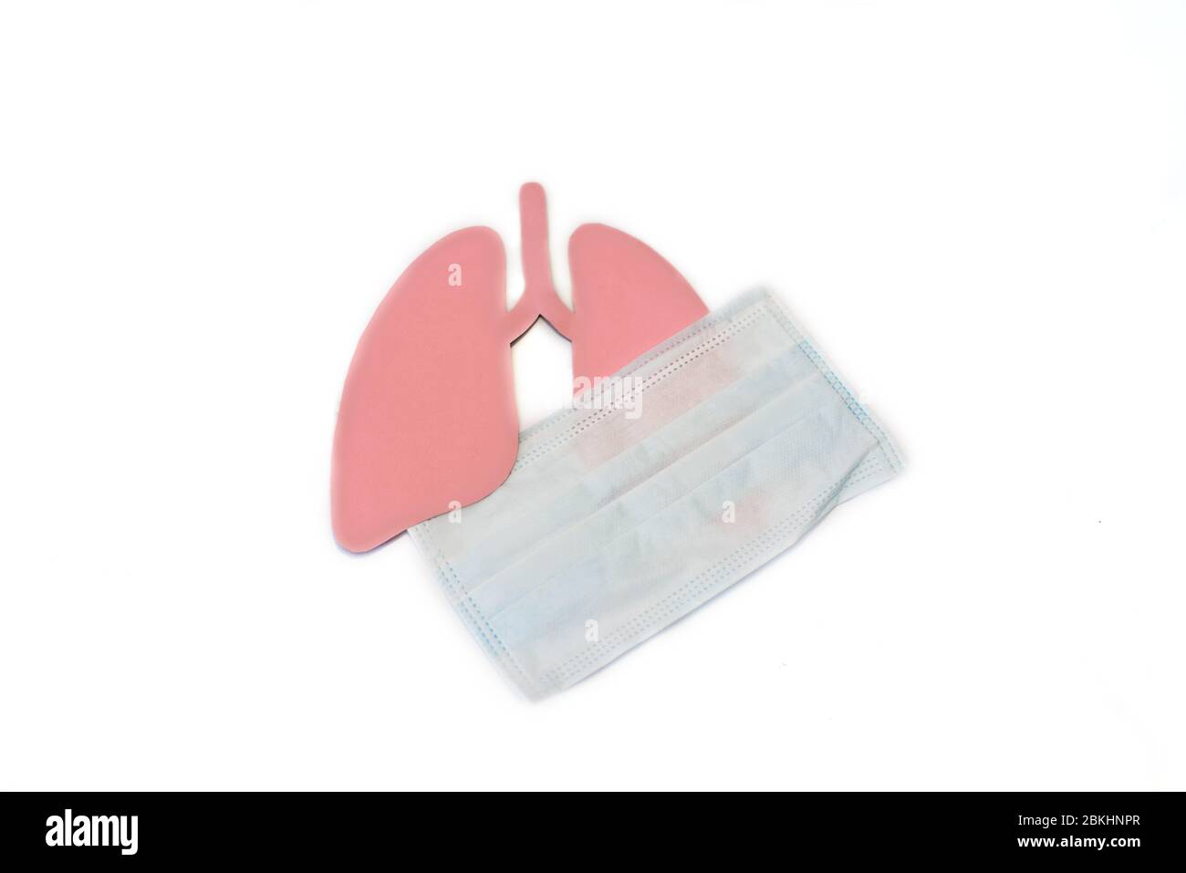 Coronavirus concept. Paper lungs with medical mask. Minimal paper art. World Tuberculosis Day or World Lung Day concept. Pink Hole Lungs as symbol of Stock Photo