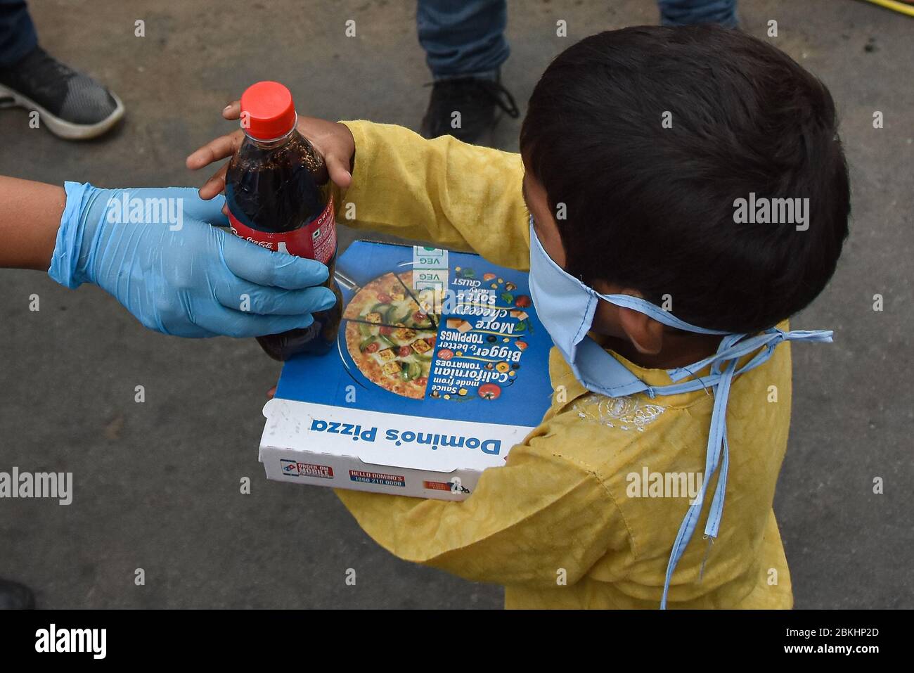 Delhi, India. 04th May, 2020. A kid receive a free pizza from Delhi district BJP Secretary Tulsi Joshi in Delhi. Tulsi Joshi in collaboration with the American multinational pizza restaurant chain Domino's Pizza offered free food for the needy amid Coronavirus (Covid-19) crisis. Credit: SOPA Images Limited/Alamy Live News Stock Photo