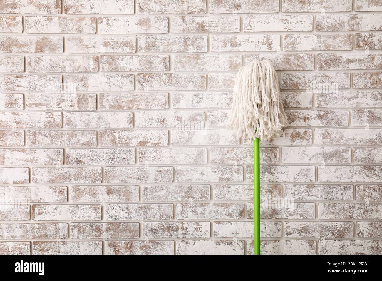 Floor mop on brick background Stock Photo - Alamy