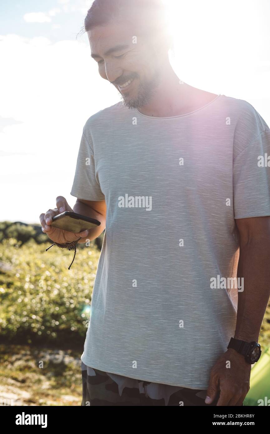 Man checking his smartphone in a sunny day Stock Photo