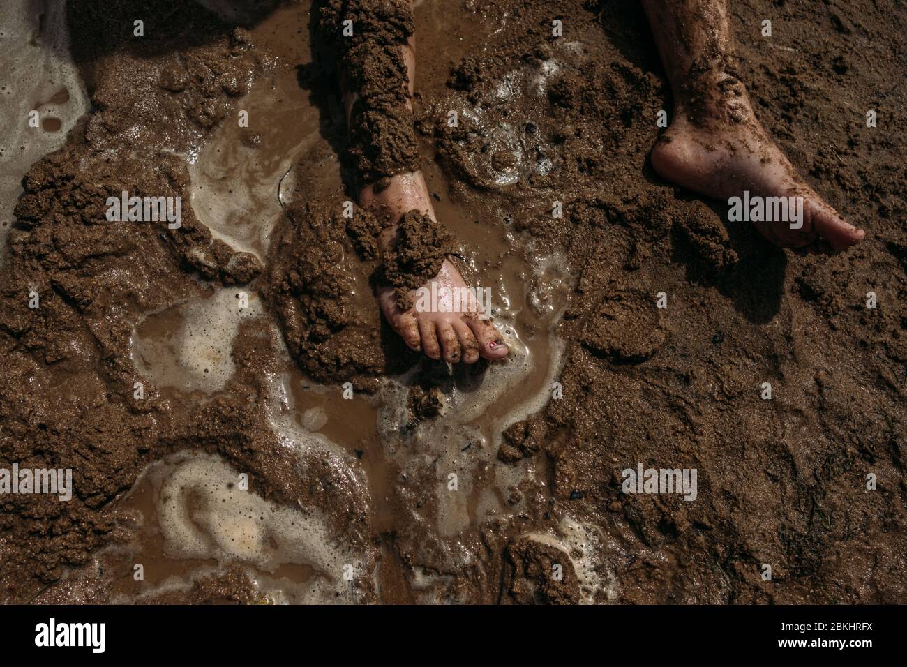 young child's legs covered in mud Stock Photo Alamy