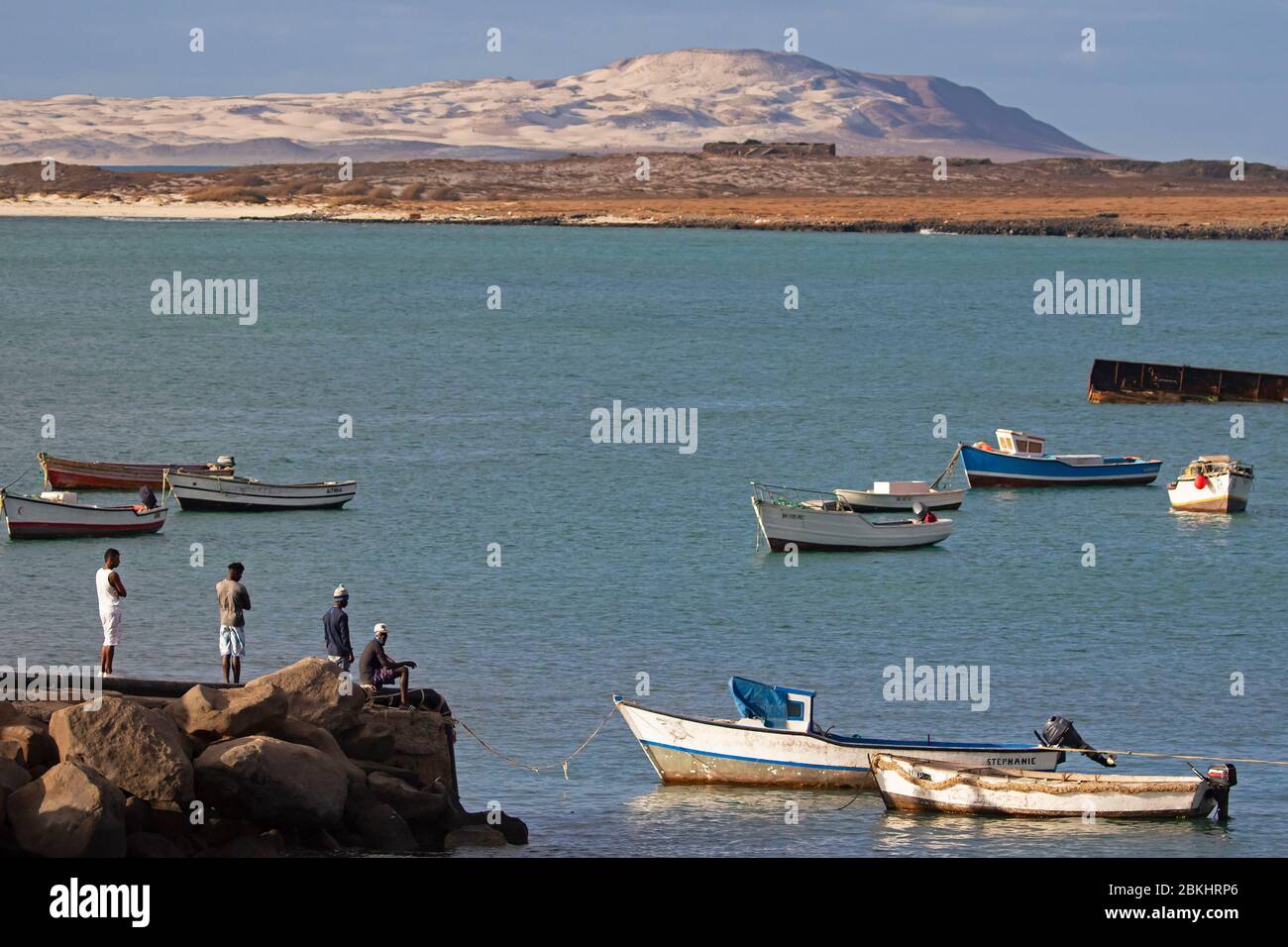 Fishermen and little fishing boats in the small harbour of Sal Rei on the island Boa Vista, Cape Verde / Cabo Verde archipelago in the Atlantic Ocean Stock Photo