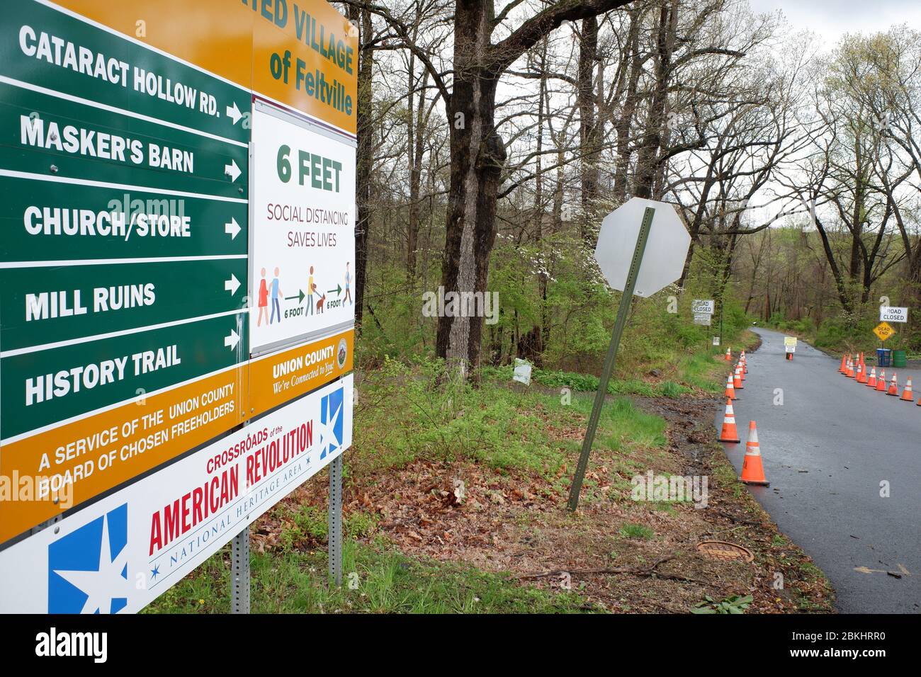 Warning sign of keep social distance at 6 feet placed on the direction sign of the Deserted Village of Feltville.Watchung Reservation, Berkeley Heights.New Jersey.USA Stock Photo