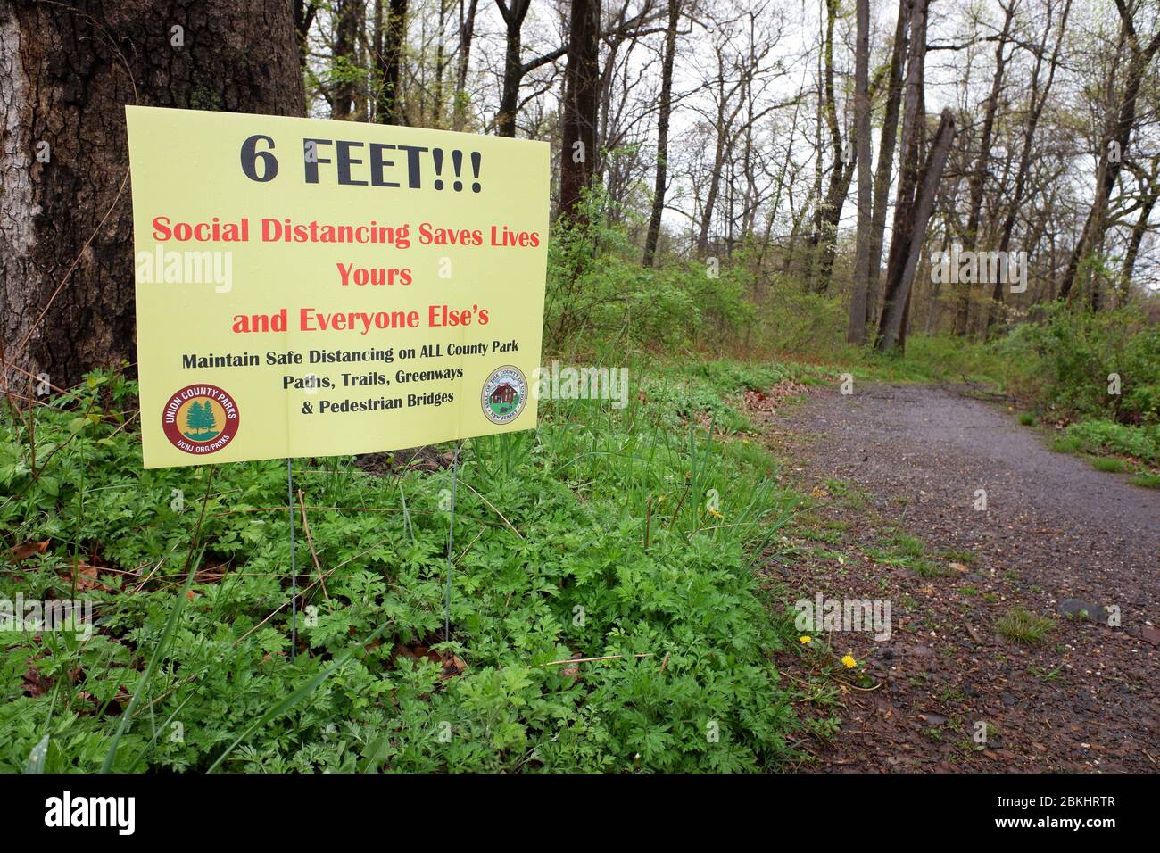 Warning sign of keep social distance by the entrance of the road to the deserted Village of Feltville during covid-19 coronavirus pandemic breakout.Watchung Reservation, Berkeley Heights.New Jersey.USA Stock Photo