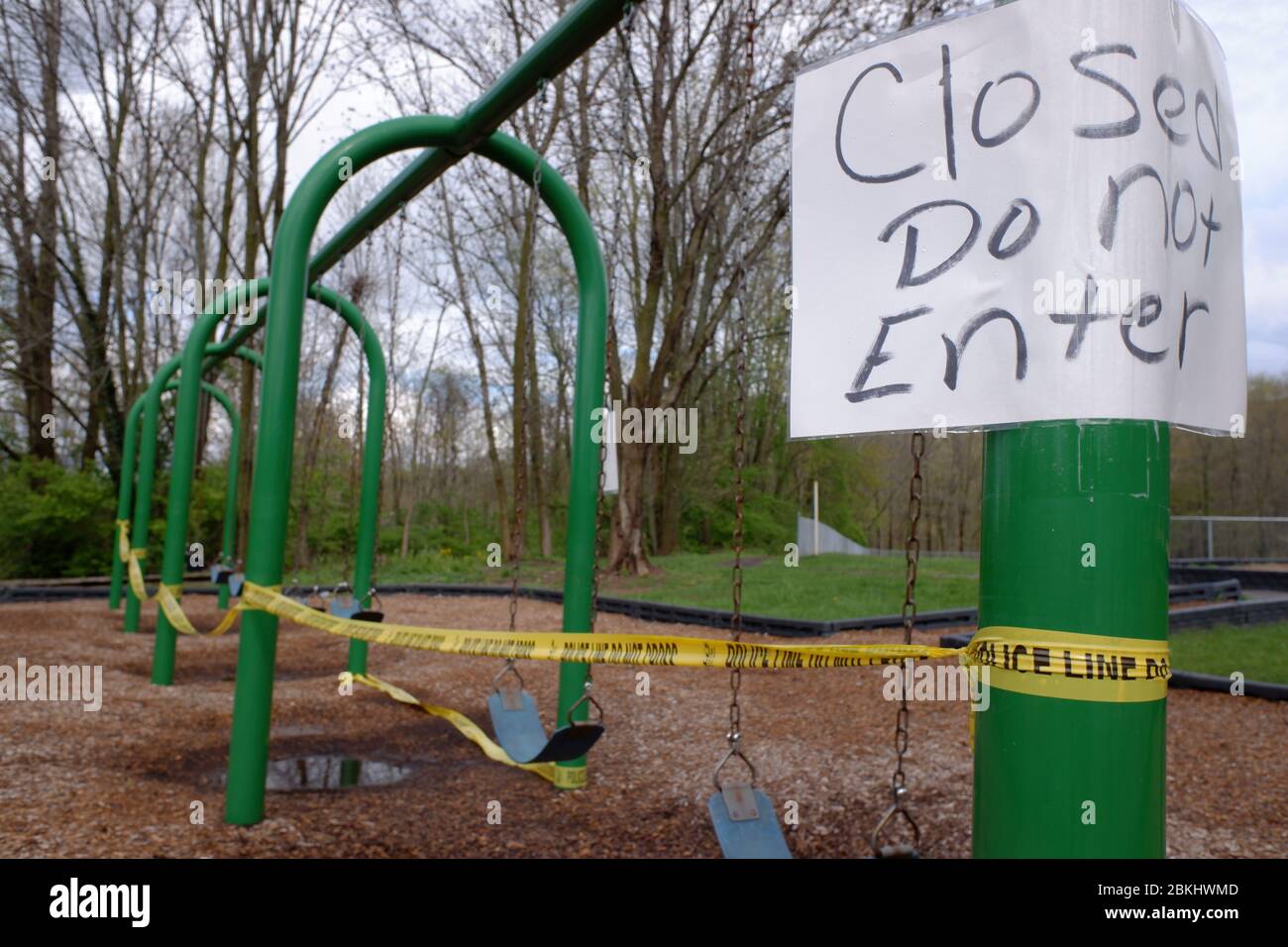 Closed do not enter sign with police line do not cross barricade tape surround a swing