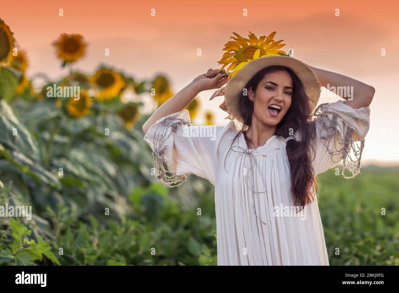 With sunflowers in the field girl posing Stock Photo - Alamy